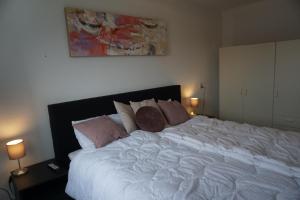 een slaapkamer met een groot wit bed met kussens bij Residence Juliana 17 in Julianadorp