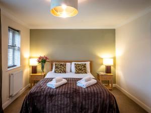 a bedroom with a large bed with two pillows at Ladybird in Bridgwater