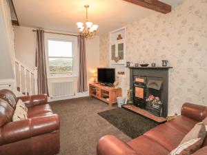 a living room with a couch and a fireplace at Street House Farm Cottage in Saltburn-by-the-Sea