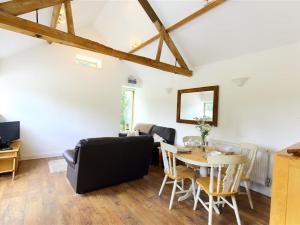 a living room with a table and chairs and a couch at The Old Dairy in Westbury on Severn