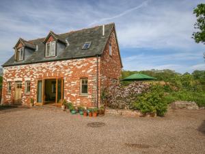 a brick house with a green umbrella in front of it at The Coach House in Exmouth
