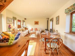 a living room with a table and a couch at The Coach House in Exmouth +18 photos