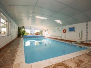 a large swimming pool with blue water at The Coach House in Exmouth