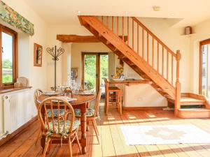a dining room with a table and a staircase at The Coach House in Exmouth