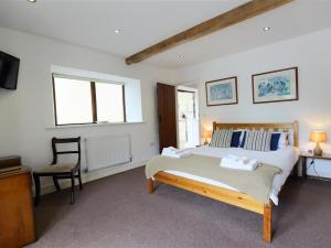 a bedroom with a bed and a desk and a chair at The Old Mill in Flaxley