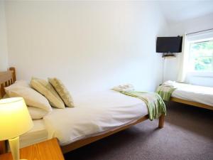 um quarto com 2 camas com almofadas e uma janela em The Old Dairy em Westbury on Severn