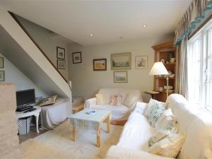 a living room with a white couch and a tv at The Mews Cottage in Tisbury