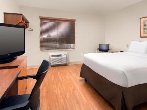 
a room with a bed, chair, television and a desk at WoodSpring Suites Wilkes-Barre in Wilkes-Barre
