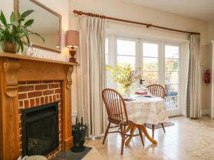 a dining room with a table and a fireplace at West Lodge in Rockbourne