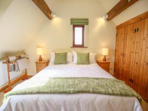 a bedroom with a large white bed with two lamps at The Coach House in Exmouth