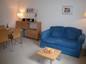 a living room with a blue couch and a table at Charter Court in Salisbury