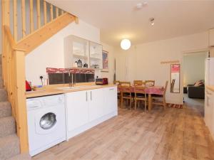 a kitchen with a washing machine and a dining room at Greencroft View, SALISBURY in Salisbury