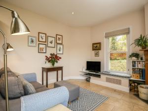 a living room with a couch and a tv at West Lodge in Rockbourne