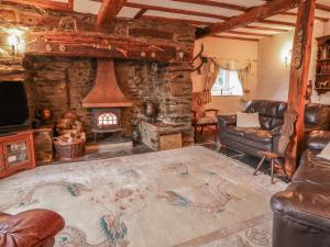 a living room with a couch and a fireplace at Pengwern in Pennant-Melangell