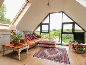 a living room with a couch and large windows at The Lookout in Llangarren