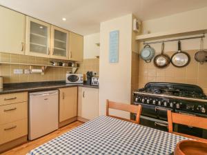 a small kitchen with a table and a stove at Sea Breeze Cottage in Buckie
