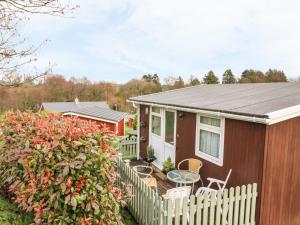 a small house with a fence and a table and chairs at Willow 80 in Carmarthen