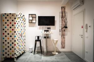 a white room with a wall with a tv and a chair at Casa Del Profumo in Piacenza