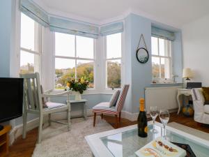 a living room with a table and some windows at Ferryside Watch in Fowey