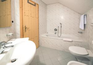 a bathroom with a sink and a tub and a toilet at Residenz am Kaiserweg in Longomoso +15 photos