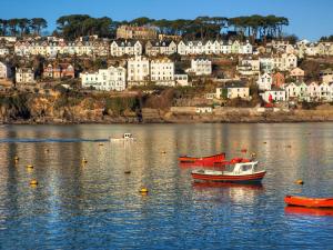 two boats on the water in front of a city at Sidings at Brunel Two in Lostwithiel