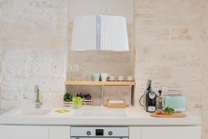 a kitchen with a sink and a counter top at Trulli Resort Aia Piccola in Alberobello