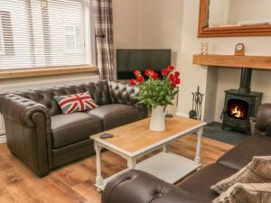 a living room with a couch and a table with a fireplace at The Sanctuary in Redcar