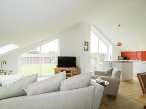 a living room with a couch and a tv at Coney Garth Retreat in Beckermet