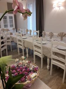 a dining room with a white table and white chairs at Agriturismo N'Uova Campagna in Bologna