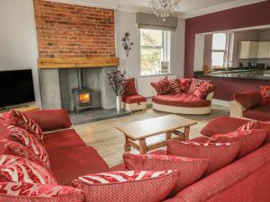 a living room with red furniture and a fireplace at Ellie's Lodge in Ulverston