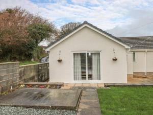 una casa blanca con una valla y un patio en Broadford Farm Bungalow, en Kidwelly