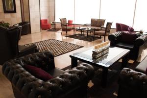 a living room with a leather couch and a table at Eden Hotel in Beirut