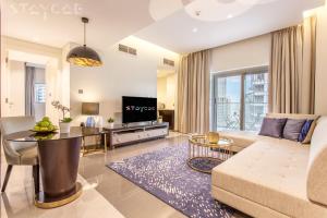 a living room with a couch and a table at Staycae Holiday Homes - Majestine in Dubai