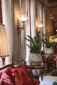 a living room with two large vases with plants in it at Albergo Terminus in Como