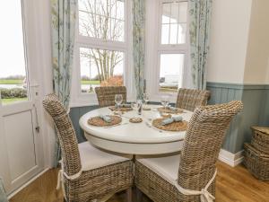 a dining room with a white table and chairs at Flat 1, Cambridge Court in Frinton-on-Sea