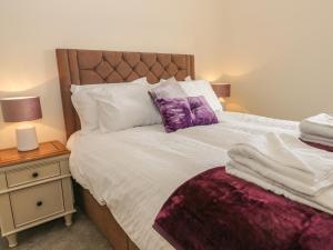 a bedroom with a large bed with purple pillows at 204 Sea View House in Redcar