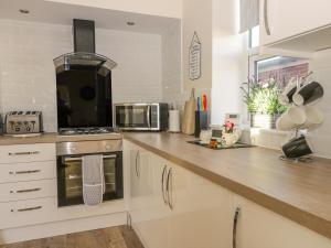 a kitchen with white cabinets and a counter top at 204 Sea View House in Redcar +16 photos