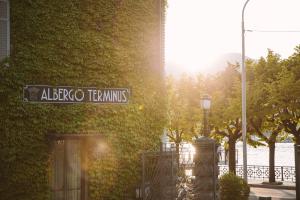 un cartello stradale per altec tenniths accanto a un edificio di Albergo Terminus a Como