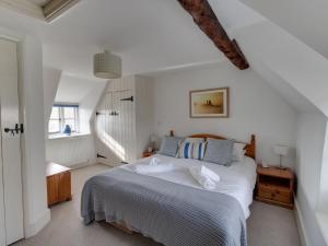 a white bedroom with a bed and a window at Farrier's Lodge in Corfe Castle