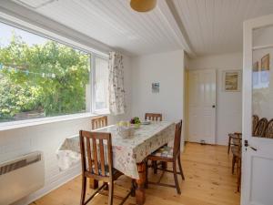 ein Esszimmer mit einem Tisch und einem Fenster in der Unterkunft Waterson in Weymouth