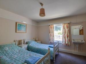 ein Schlafzimmer mit zwei Betten und einem Fenster in der Unterkunft Waterson in Weymouth