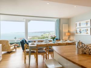 a dining room and living room with a table and chairs at Oyster Bay in Port Isaac