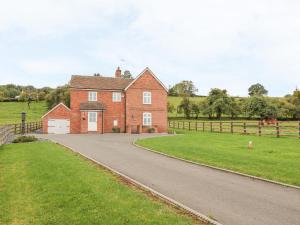 a large red brick house with a driveway at Orchard Cottage in Tenbury