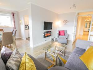 a living room with a couch and a fireplace at Cumbrae View in Largs
