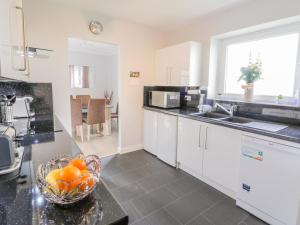 a kitchen with a bowl of oranges on a counter at Cumbrae View in Largs