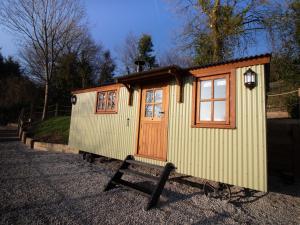 a small shed with a wooden door and windows at Little Silver Leaf in High Bickington