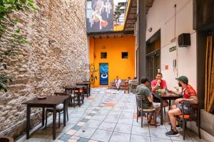 a group of people sitting at tables in a restaurant at Granados Hostel in Buenos Aires