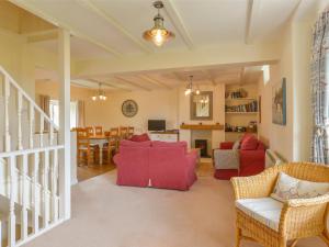 a living room with red furniture and a dining room at St Aubyn Cottage in Plymouth