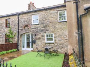 a stone house with a table and chairs in front of it at Linden Cottage in Smardale