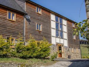 an old house with wooden walls and windows at The Stables in Knighton